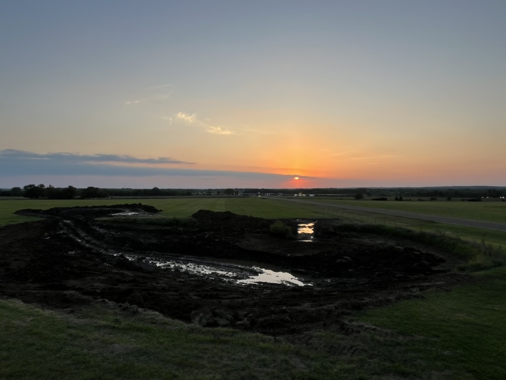 Pond being dredged at sunset